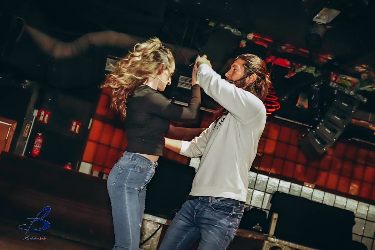 Ola bailando bachata con una pareja en una pista de baile