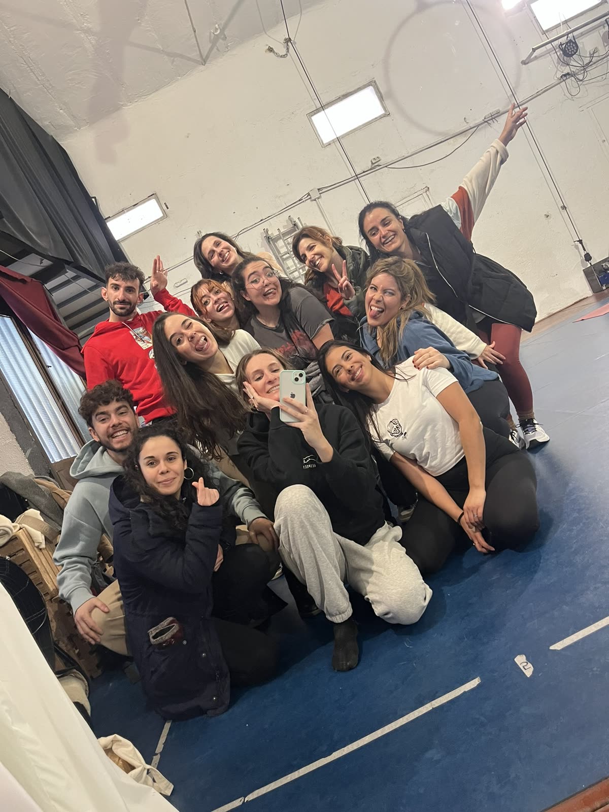 A group class posing together in front of the studio mirror