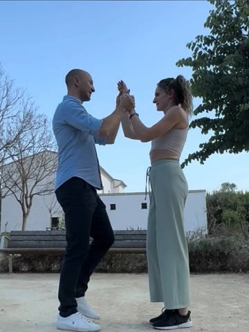 A couple practicing partner work outdoors during a private lesson