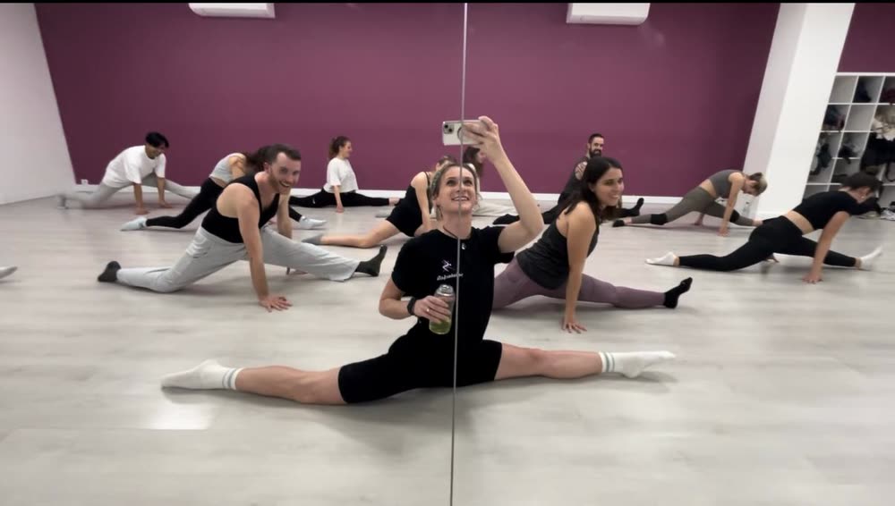 Ola in a full front split during a group stretching class