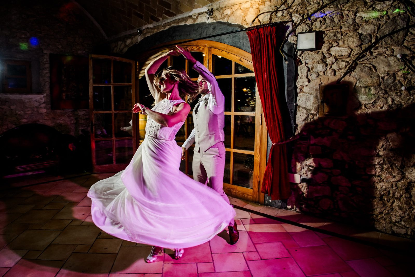 A bride and groom sharing their first dance under an archway